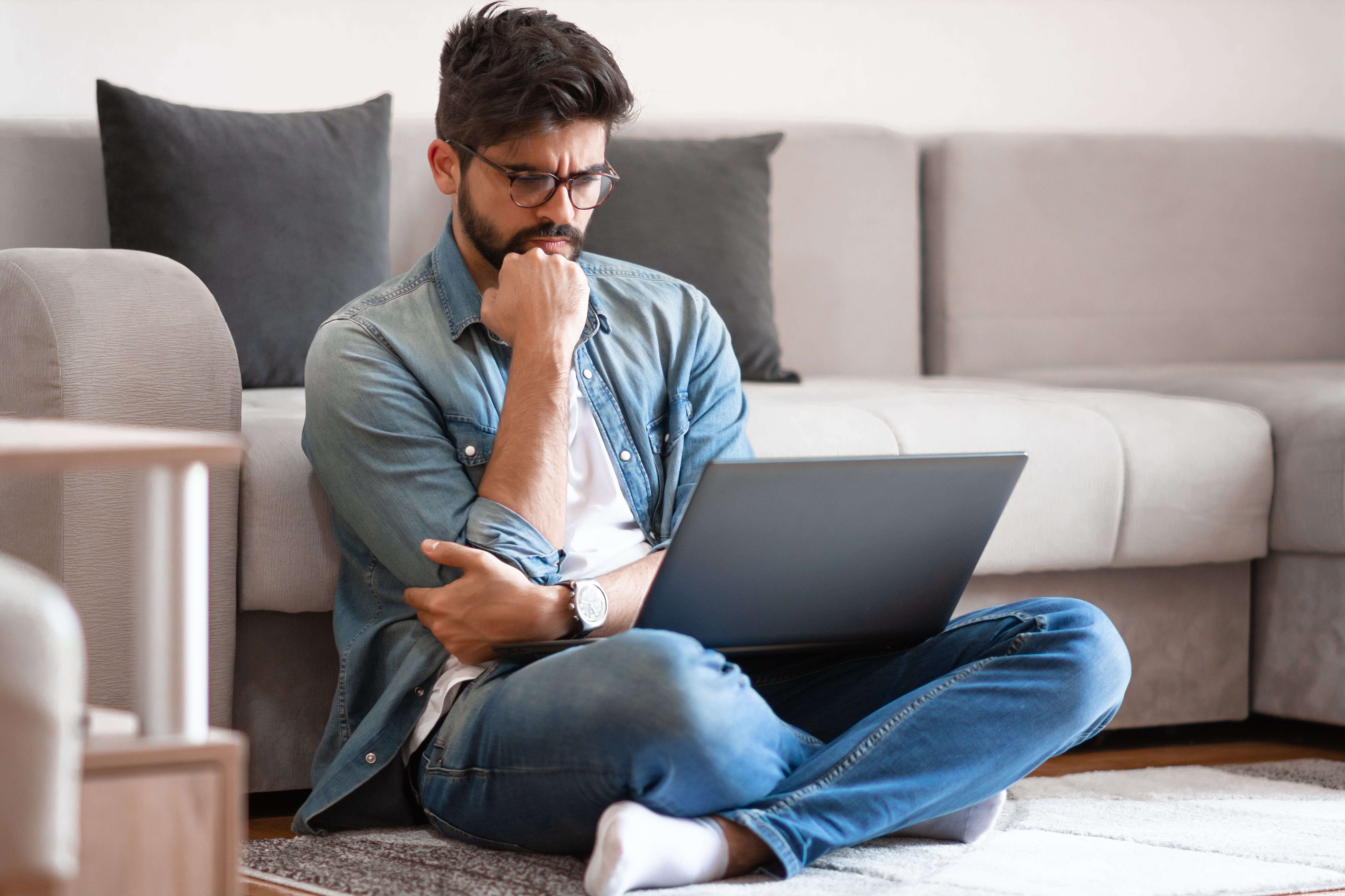 Homme qui à l'air perplexe devant son ordinateur